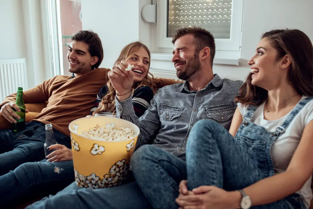 Eine Gruppe von Freunden, die sich zu Hause treffen und Popcorn essen